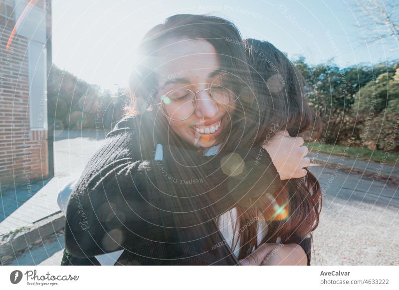 Zwei Universitätsstudenten Freunde umarmen einander glücklich nach dem Treffen wieder auf dem Campus nach den Ferien. Hug schöne Konzept. Studie und lernen zusammen Konzept. Zurück zu Schule und Klasse.