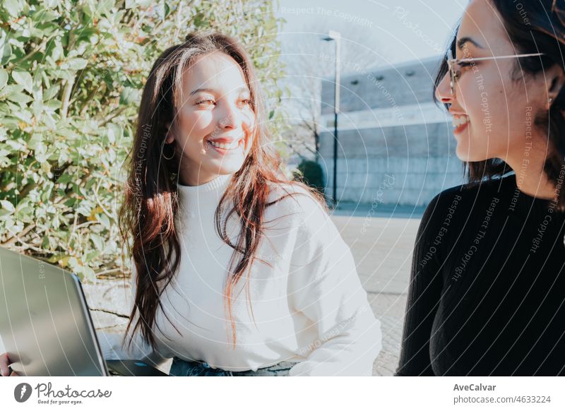 Afrikanisch-arabisches Studentenpaar, das außerhalb des Campus studiert, während es an seinen Laptops arbeitet und lernt, ein Projekt diskutiert, das es in der Klasse vorstellen will, und unter der Sommersonne fleißig lernt. Zurück zum Unterricht