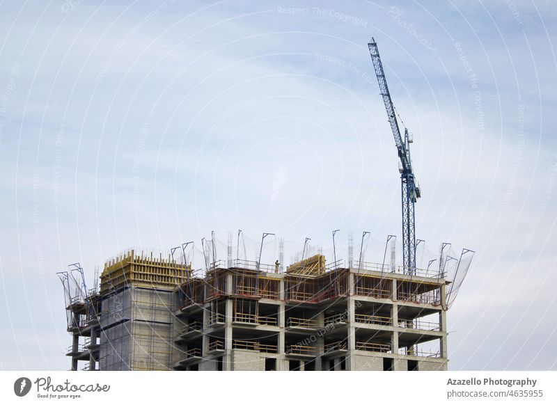 Unfertiges mehrstöckiges Gebäude mit einem Hebekran. Appartement Architektur Hintergrund blau Blauer Himmel erbaut Business Zement Großstadt Konzept Beton