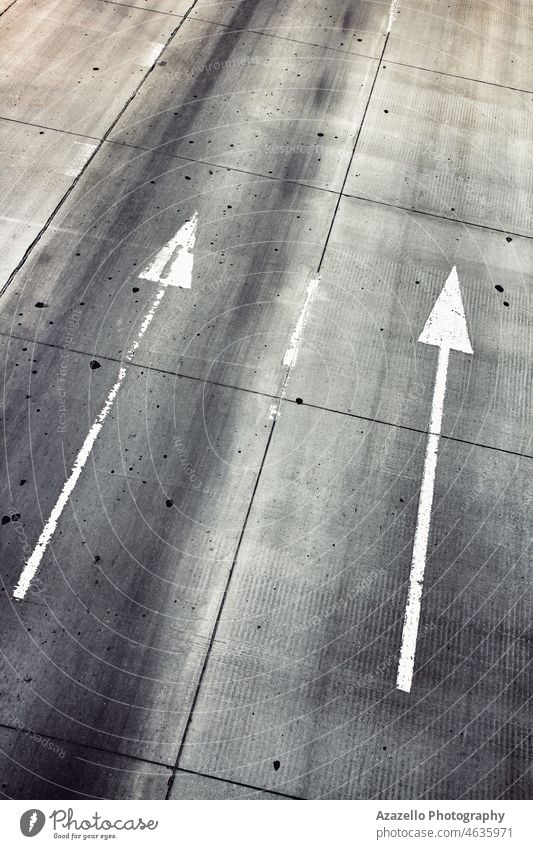 Weiße parallele Richtungspfeile auf einer Autobahn. zielen Winkel Gegend Pfeil Asphalt Hintergrund schwarz Business Großstadt Konzept konzeptionell Beton