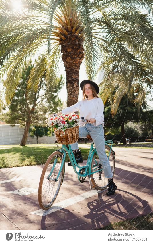 Junge Frau fährt Fahrrad im Park Mitfahrgelegenheit Weg Blume Wochenende tropisch Stil Sommer lässig Blumenstrauß jung exotisch frisch Blüte Gasse Fahrzeug