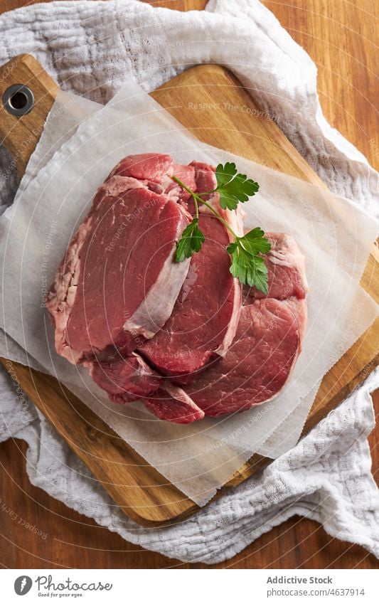 Rohe Rinderlendenstücke auf dem Schneidebrett Rindfleisch Lendenstück Filet Fleisch Küche roh Lebensmittel kulinarisch ungekocht Kraut Pergament vorbereiten