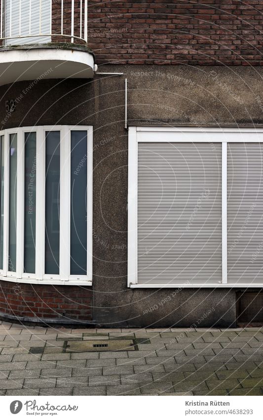 fassade mit rundung, putz und backstein haus fenster gebäude rolladen rollladen jalousie rollo geschlossen 52 hausnummer balkon geländer balkongeländer altbau