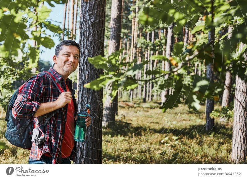 Mann mit Rucksack beim Wandern im Wald, der seinen Sommerurlaub aktiv in der Natur verbringt wandern Ausflug Trekking Reise laufen Erholung reisen Fernweh