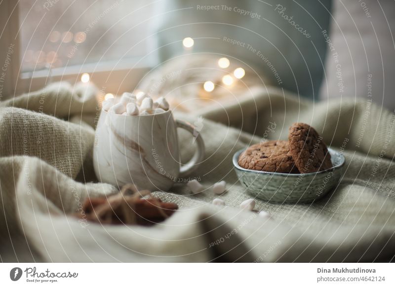 Gemütliches Weihnachtsfrühstück zu Hause. Weihnachten Zimt Cookies mit Tasse Kakao mit Marshmallows. Gemütliche entspannende Momente auf der Fensterbank zu Hause mit süßem Dessert, das Leben zu genießen.