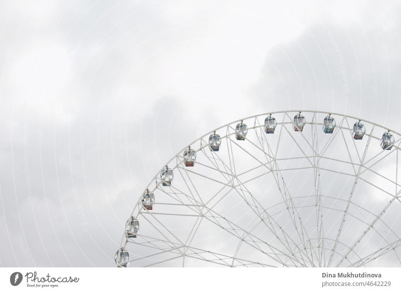 Ein Teil der ferris und bewölkten grauen Himmel. Entsättigter Hintergrund mit Riesenrad. Licht, grau, weiß, Himmel, Riesenrad. Rad Vergnügen Vergnügungspark