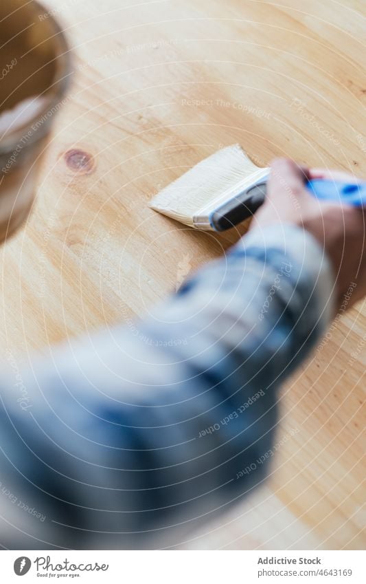 Anonyme Frau mit Glas mit Holzlack Tischlerin beenden Belag Holzarbeiten Werkstatt Arbeit hölzern Holzplatte Schiffsplanken Herstellung professionell