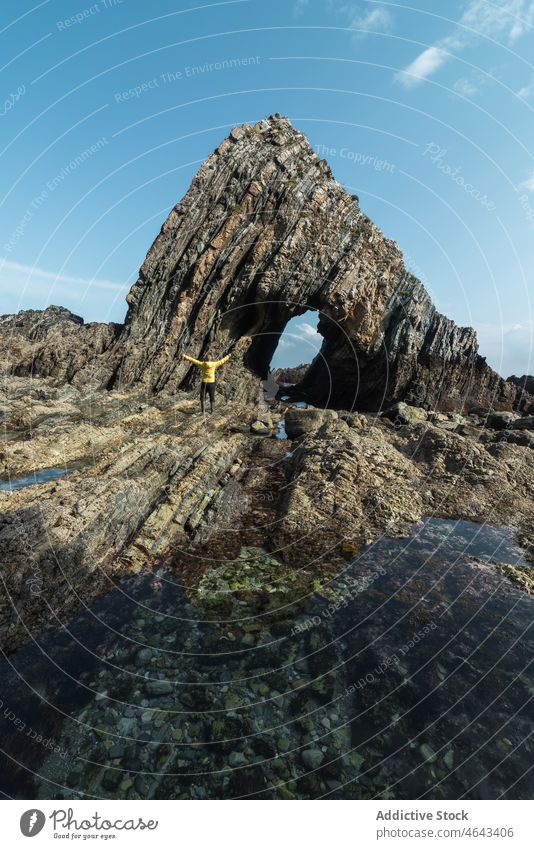 Anonymer Reisender in der Nähe eines Felsens am Ufer Ausflug Abenteuer Strand Klippe MEER Wasser Küste Natur Stein Asturien Spanien Formation rau wolkig