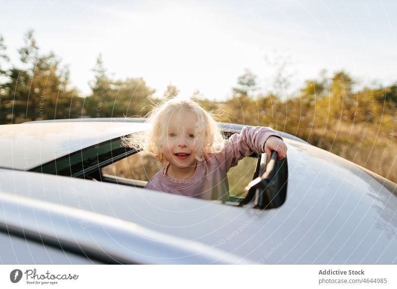 Nettes Mädchen im Schiebedach eines Autos Kind PKW Autoreise Zeitvertreib Passagier Landschaft Automobil Freizeit Arbeitsweg Fahrzeug Reise Verkehr Abenteuer