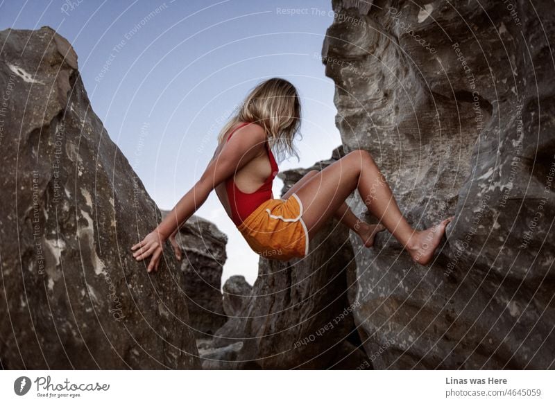 Es ist immer eine gute Idee, Vietnam zu besuchen. Klettern Sie auf ein paar Felsen und zeigen Sie Ihre schönen langen Beine. Bekleidet mit einem roten Badeanzug und orangefarbenen Shorts. Wie dieses wunderschöne blonde Mädchen.