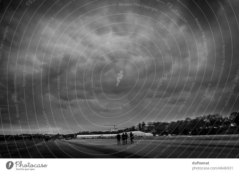 extreme Wolkenformation am Himmel über großem Platz Weite Schwarzweißfoto dunkel Abend bewölkt bewölkter himmel Landschaft bewölkter Himmel