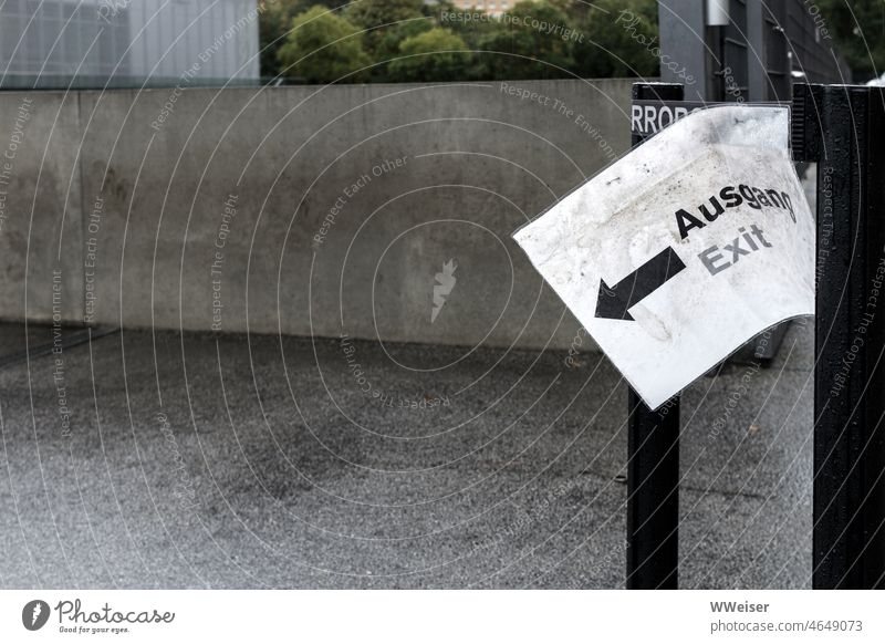 Beton, Regen, Tristesse. Falls jemand aussteigen möchte - zum Ausgang geht es dort drüben. Hinweis Pfeil Schild Zettel Papier nass feucht draußen menschenleer