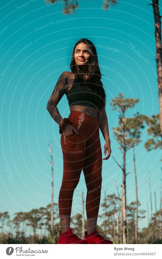 Spanische junge Frau, die im Park steht und sich die Sonne ins Gesicht scheinen lässt. Wald State Park landschaftlich reisen Eleganz hispanisch