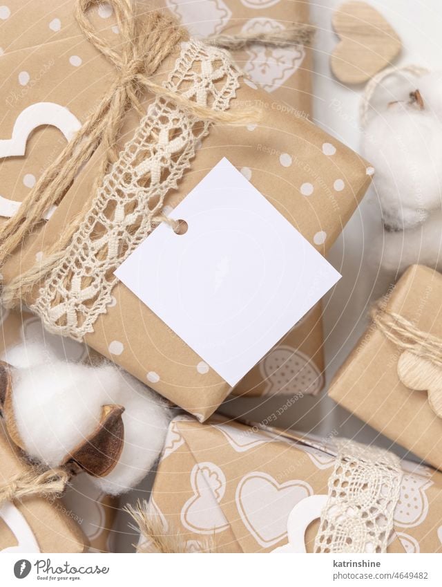 Valentinstag Geschenk mit leeren Geschenk-Tag und Herz schließen, Rustic Label Mockup Valentinsgruß Geschenkanhänger Attrappe präsentieren eingewickelt beige