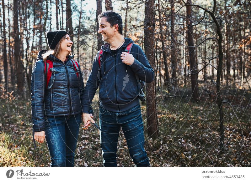 Paar hält sich an den Händen und genießt die Reise am Urlaubstag. Wanderer mit Rucksäcken zu Fuß auf Waldweg an einem sonnigen Tag Ausflug wandern Abenteuer