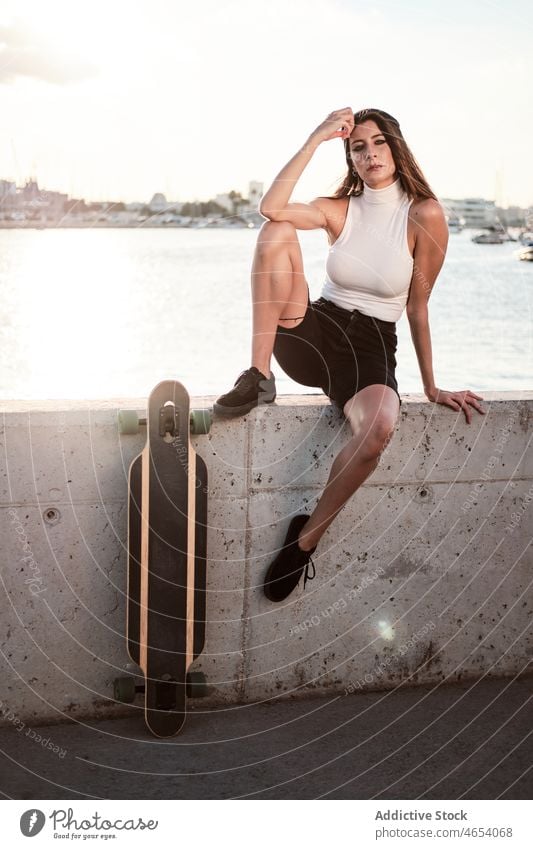 Frau mit Longboard an Böschung MEER Stauanlage Sommer Stil sich[Akk] entspannen Wochenende Freizeit Vorschein Meeresufer jung trendy Skater Glück Wasser Borte