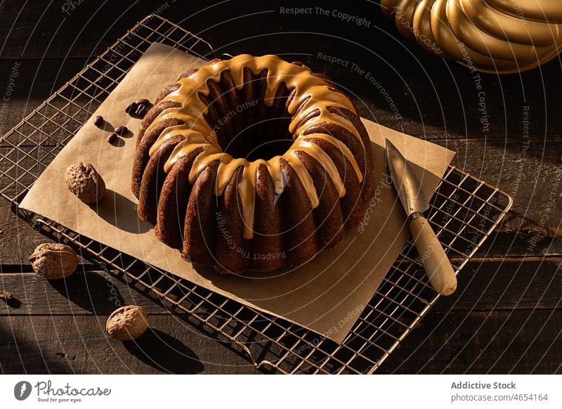 Kaffee-Walnuss-Gugelhupf auf rustikalem Holztisch Bundkuchen Leckerbissen festlich Schwamm brauner Hintergrund Winter Küche Essen zubereiten Messer