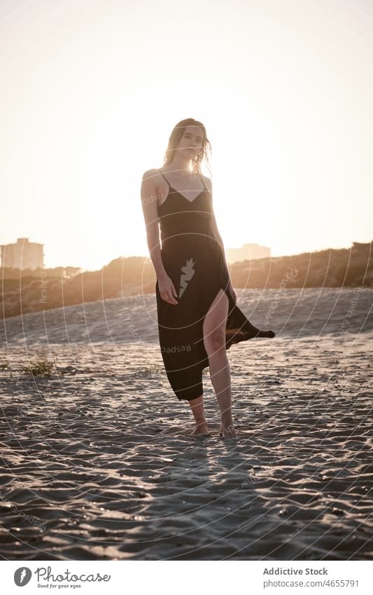 Schlanke attraktive Frau steht am Sandstrand in sonnigen Tag wüst Sommer wolkenlos Blauer Himmel Barfuß Sonne Kleid Harmonie Sonnenkleid tagsüber Strand reisen