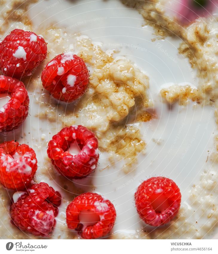 Nahaufnahme von Porridge mit Milch, Haferflocken und Himbeeren. Gesundes Frühstück Haferbrei melken Gesundheit saisonbedingt Sommer Beeren Draufsicht