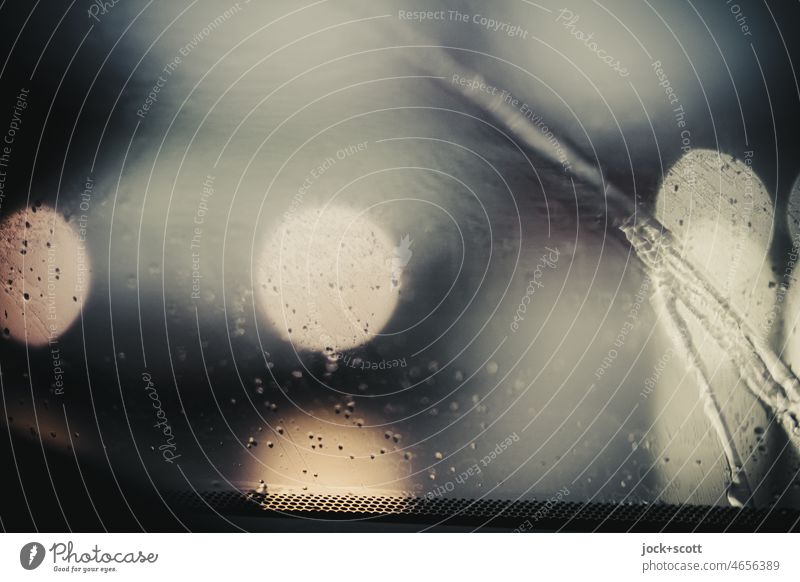 Licht im Gegenverkehr … bei Regen in der Dämmerung … Windschutzscheibe Regentropfen Auto Frontscheibe defokussiert abstrakt Reflexion & Spiegelung verschwommen