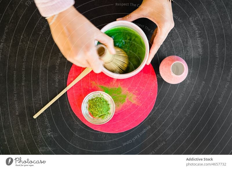 Frau mit Bambusbesen bei der Zubereitung von Matcha-Tee chasen Kultur vorbereiten Schneebesen Wasser Pulver Getränk frisch Gesundheit gesunde Ernährung