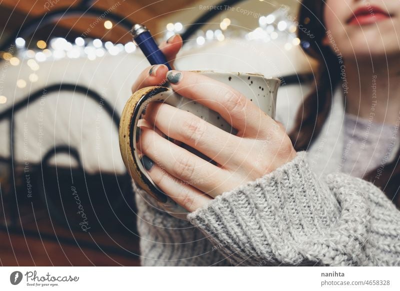 Frau hält eine warme Tasse Kaffee in den Händen Tee Herbst Töne Licht Bokeh Wolle Wollstoff Pullover heimwärts jung Jugend Halt Beteiligung schwarz Wärme