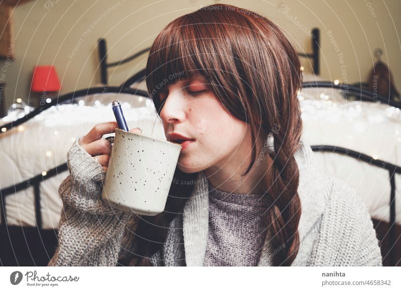 Junge und verträumte Frau genießt eine Tasse Kaffee heimwärts warm Tee Winter Herbst Stimmung Porträt Komfort ruhig Ruhe Leben Lifestyle bequem niedlich brünett