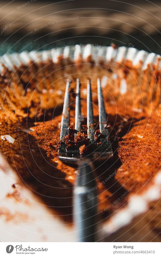 Gabel mit Schokoladenmuffin-Krümeln, die auf ein Muffinpapier gelegt werden. Holz Feuer braun Essen zubereiten Natur dunkel rot backen Deckblatt Utensilien