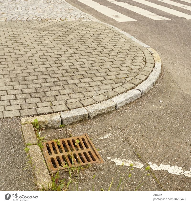 ein Stück gepflasterter Fußweg, ein Stück asphaltierte Straße, ein Zebrastreifen, eine Straßenmarkierung und ein gusseiserner Gullydeckel im Quadrat / Mustermix