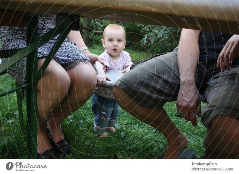 Kleinkind zwischen Mutter und Vater unter einem Biertisch Eltern Baby elternzeit Familie & Verwandtschaft Erwachsene Kind Zusammensein dazwischen Garten