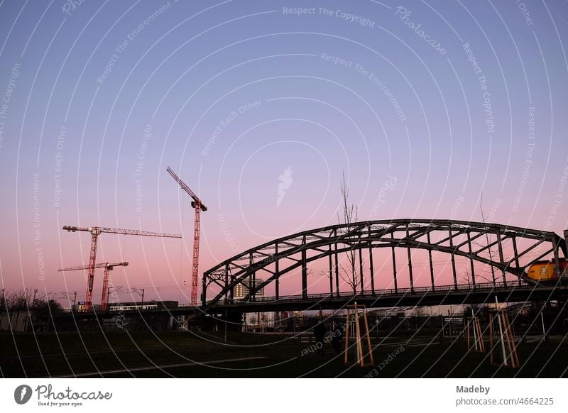 Abendrot und Baukräne hinter der Deutschherrnbrücke am Abend im Ostend von Frankfurt am Main in Hessen Urbanität Rhein-Main-Gebiet Gewerbegebiet Industriegebiet