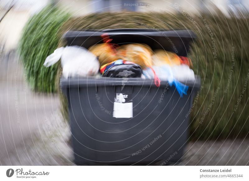 Übervolle Mülltonne im Wirbel Müllbehälter Außenaufnahme dreckig Recycling Müllentsorgung wegwerfen Umweltschutz Müllverwertung Müllabfuhr Umweltverschmutzung