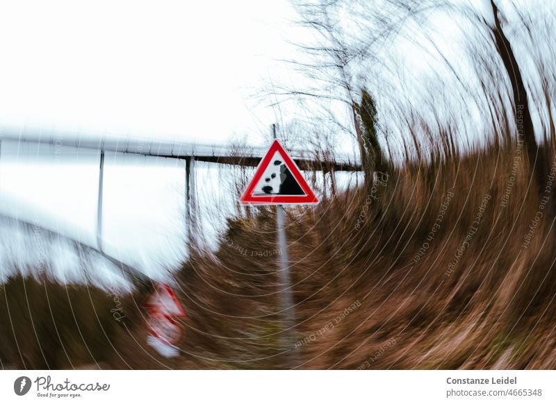 Verkehrsschild Steinschlag im Wirbel vor Brücke Geschwindigkeit Straße Bewegung PKW fahren Verkehrsmittel Straßenverkehr Verkehrswege Bewegungsunschärfe