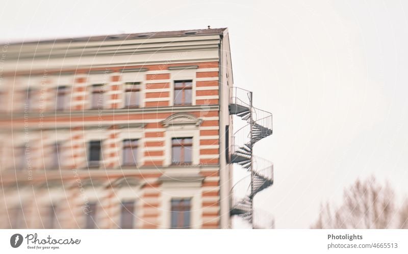 Außenwendeltreppe an Haus - Wo führt sie hin? Wendeltreppe Hauswand Stufen Geländer Fenster Mehrfamilienhaus Mehrstöckig Treppe aufwärts abwärts wohnen