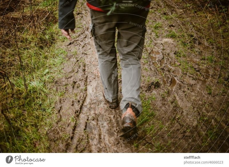 Wanderung durch den Matsch Weg wandern Wanderschuhe Hose Rucksack Regen Erde Wald Waldwanderung Schlamm feuchte Erde Dreck Schlick glitschig matschig dreckig