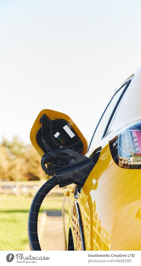 Nahaufnahme eines an ein Elektroauto angeschlossenen Netzteils beim Aufladen elektrisch PKW Gebühr Stecker verstopft EV Schnellladegerät Station Tankstelle