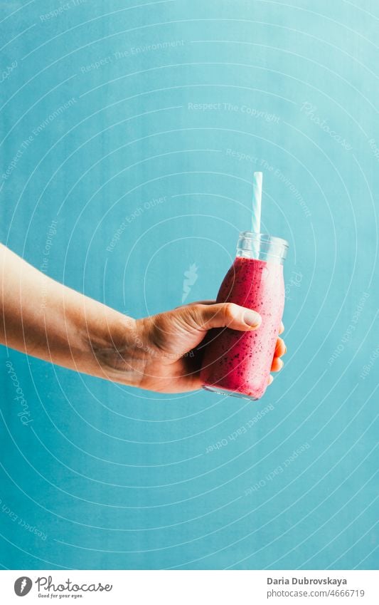 Beeren-Smoothie in der Hand auf blauem Hintergrund Essen zubereiten Produkt Bestandteil selbstgemacht purpur Joghurt schütteln Rezept Entzug Protein organisch