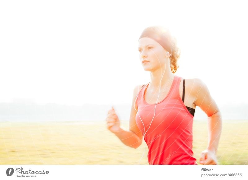 Frau läuft in der sonnigen Natur mit Kopfhörern auf Sport Fitness Sport-Training Leichtathletik Sportler Joggen feminin Junge Frau Jugendliche 1 Mensch