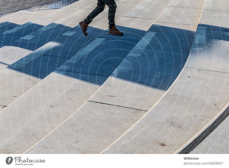 Kinderbeine laufen im Schatten eine breite Treppe hoch Stufen Beine steigen Herbst Winter Licht Sonne Schritte weit Promenade Hafen geometrisch minimalistisch