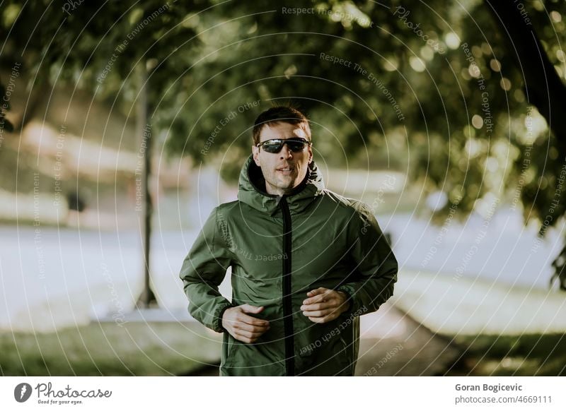 Sportlicher junger Mann, der in einem sonnigen grünen Park trainiert Aktion aktiv Aktivität Erwachsener Athlet sportlich Kaukasier Ausdauer Übung passen Fitness