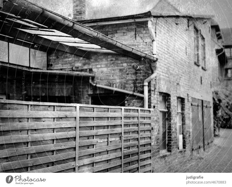 Ribnitz-Damgarten Gebäude Haus Zaun Sichtschutz Holzzaun Dach Wand Ziegelwand Fenster Tor Weg Straße Mauer alt Bauwerk trist grau Fassade Stadt