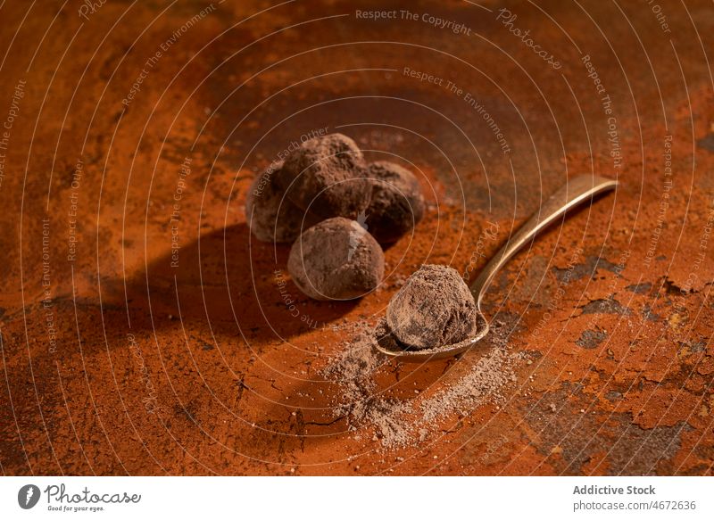 Löffel mit Trüffeln und Kakaopulver auf rostiger Oberfläche Schokolade Dessert süß Pulver lecker geschmackvoll Zucker Kalorie Tisch schmackhaft Feinschmecker