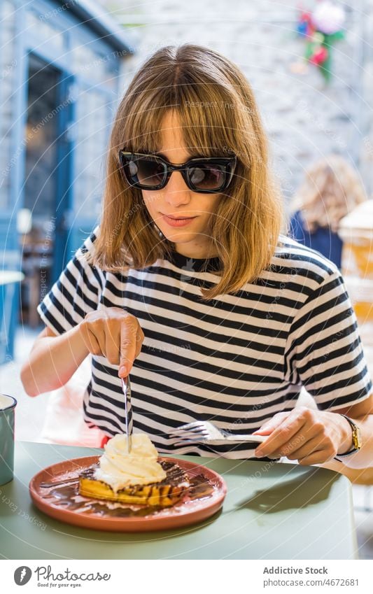 Fröhliche Frau isst Dessert auf der Terrasse eines Cafés Waffel Speiseeis süß essen Feinschmecker Leckerbissen lecker geschmackvoll Lebensmittel Geschmack