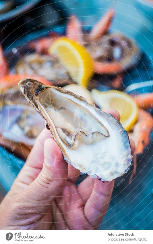 Unbekannte Person mit Auster im Restaurant essen Meeresfrüchte Feinkostladen Exquisit Küche Feinschmecker Delikatesse lecker Zitrone geschmackvoll Lebensmittel