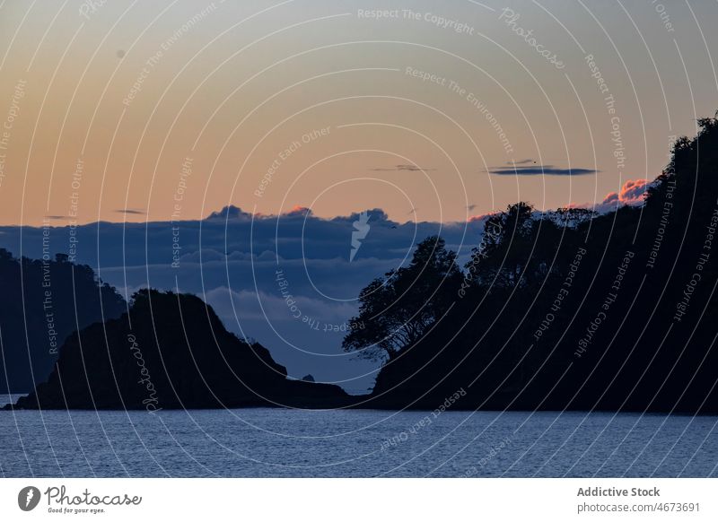 Meer mit Klippen bei Sonnenuntergang MEER Wasser Berge u. Gebirge Baum Natur Abend Meereslandschaft Rippeln Meerwasser tropisch Himmel Umwelt Dämmerung aqua