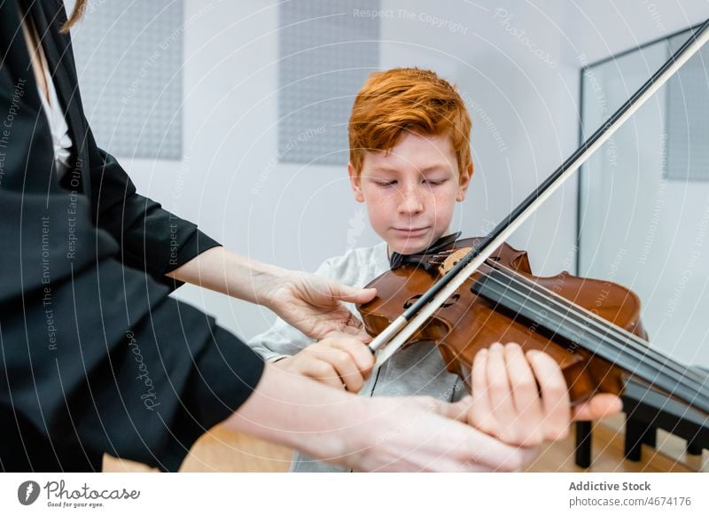 Junge und Lehrer beim Geigenunterricht Klasse Kind Schleife lehren Musik Schule lernen professionell Frau Klassenraum Lektion Musiker Klang ausführen Lernender