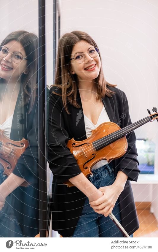 Zufriedene Frau mit Geige in der Musikschule Schule Schüler heiter Musiker Klassenraum klassisch Instrument Schleife Glück Bildung Klang positiv Inhalt Lächeln