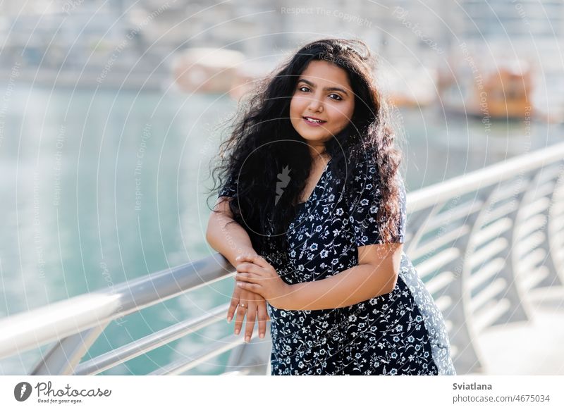 Porträt eines schönen indischen Mädchens, das an der Brüstung auf dem Damm steht. Frau asiatisch Stauanlage Spazierweg laufen Straße positive Emotion