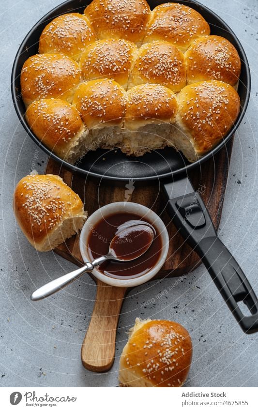 Brötchen in der Bratpfanne auseinanderziehen rollen Bäckerei Brot Saucen Sesam Gebäck selbstgemacht gebacken frisch süß Lebensmittel Schneidebrett Samen lecker