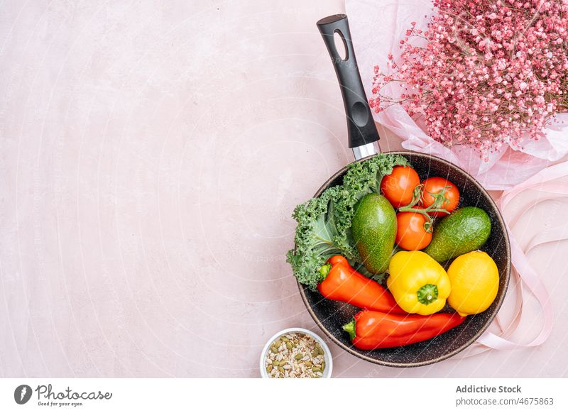 Bratpfanne mit rohem Gemüse in der Nähe von Gypsophila-Blüten gesunde Ernährung Paprika Avocado Tomate Blume Blumenstrauß geblümt Suppengrün organisch Vitamin